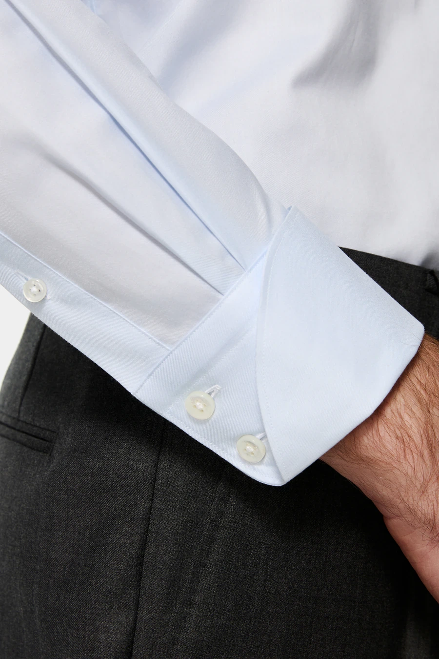 Close-up of a pale blue dress shirt with a buttoned cuff