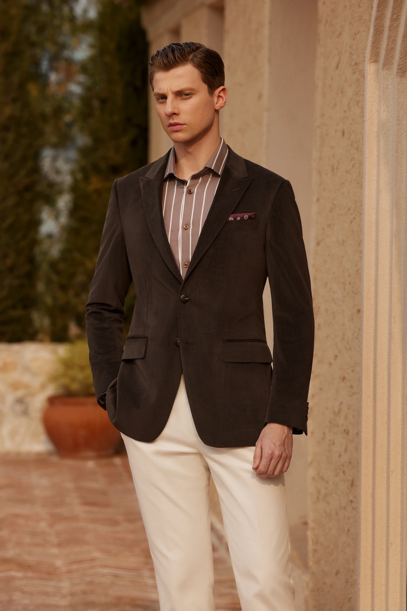 Man wearing a brown blazer with cream trousers