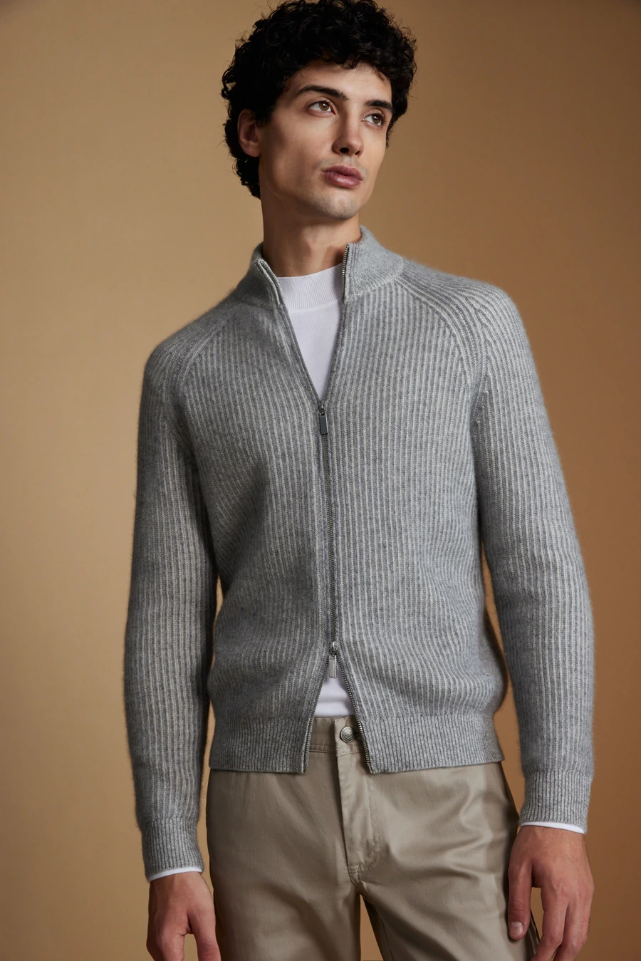 Man wearing a grey zip cardigan with beige trousers