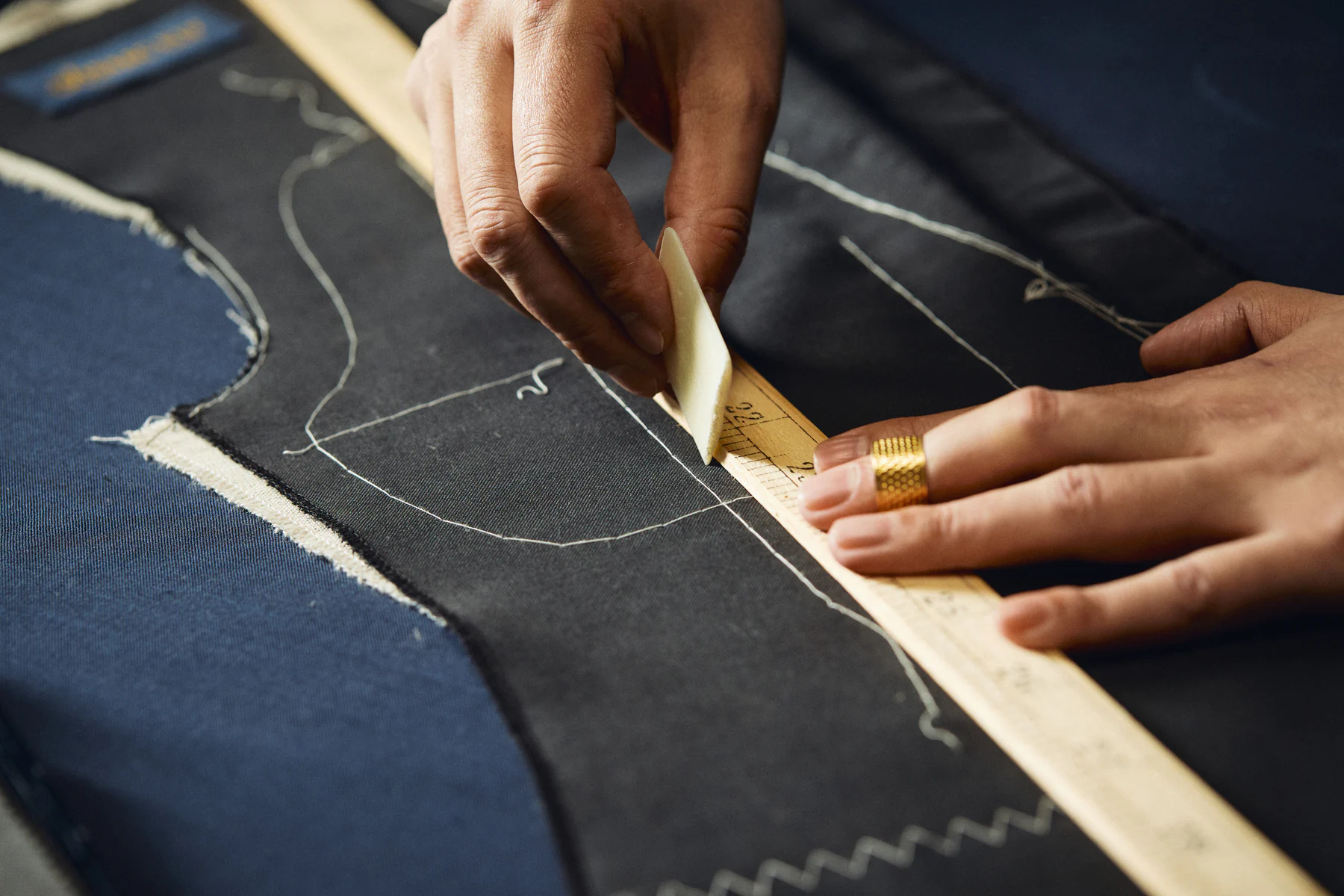 Tailor hand-stitching the lapel of a bespoke jacket