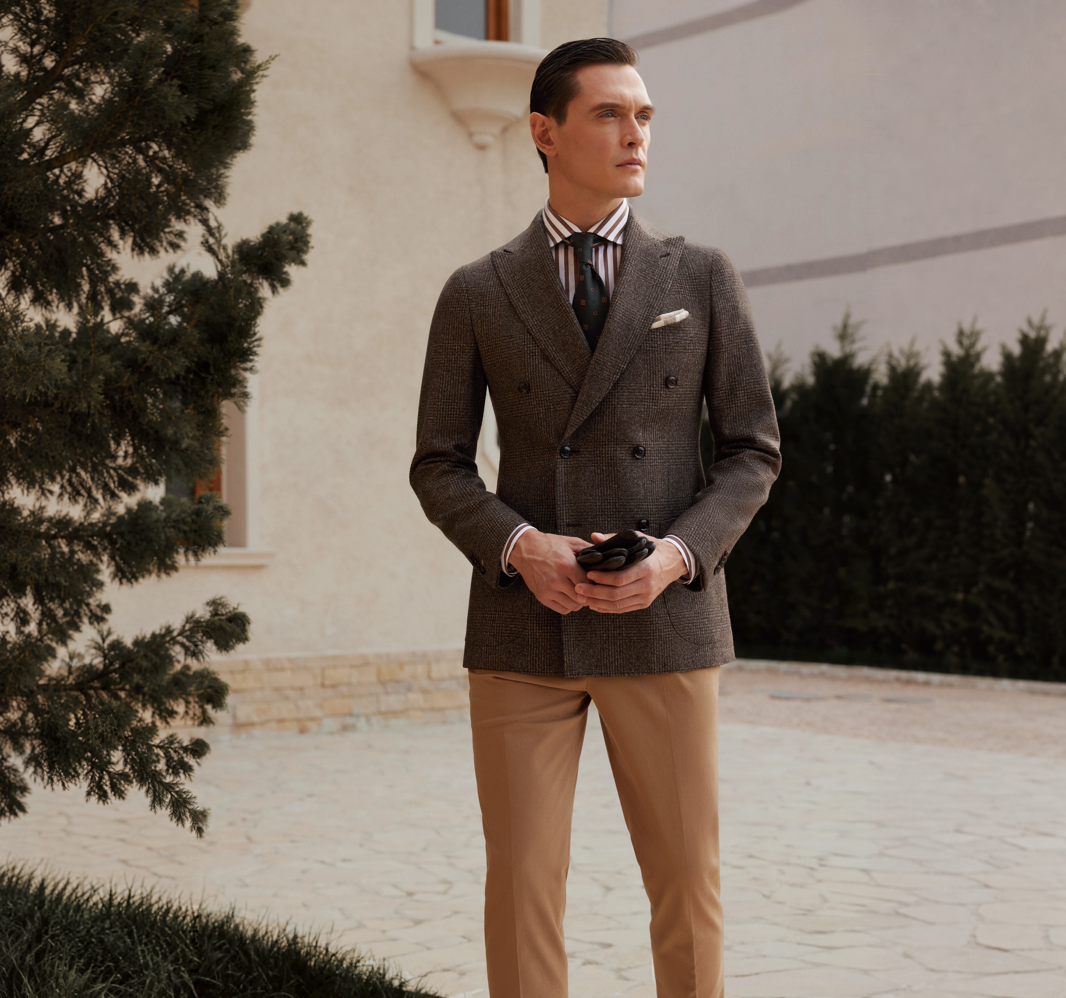 An anonymous client viewing a coordinated bespoke wardrobe in a private atelier