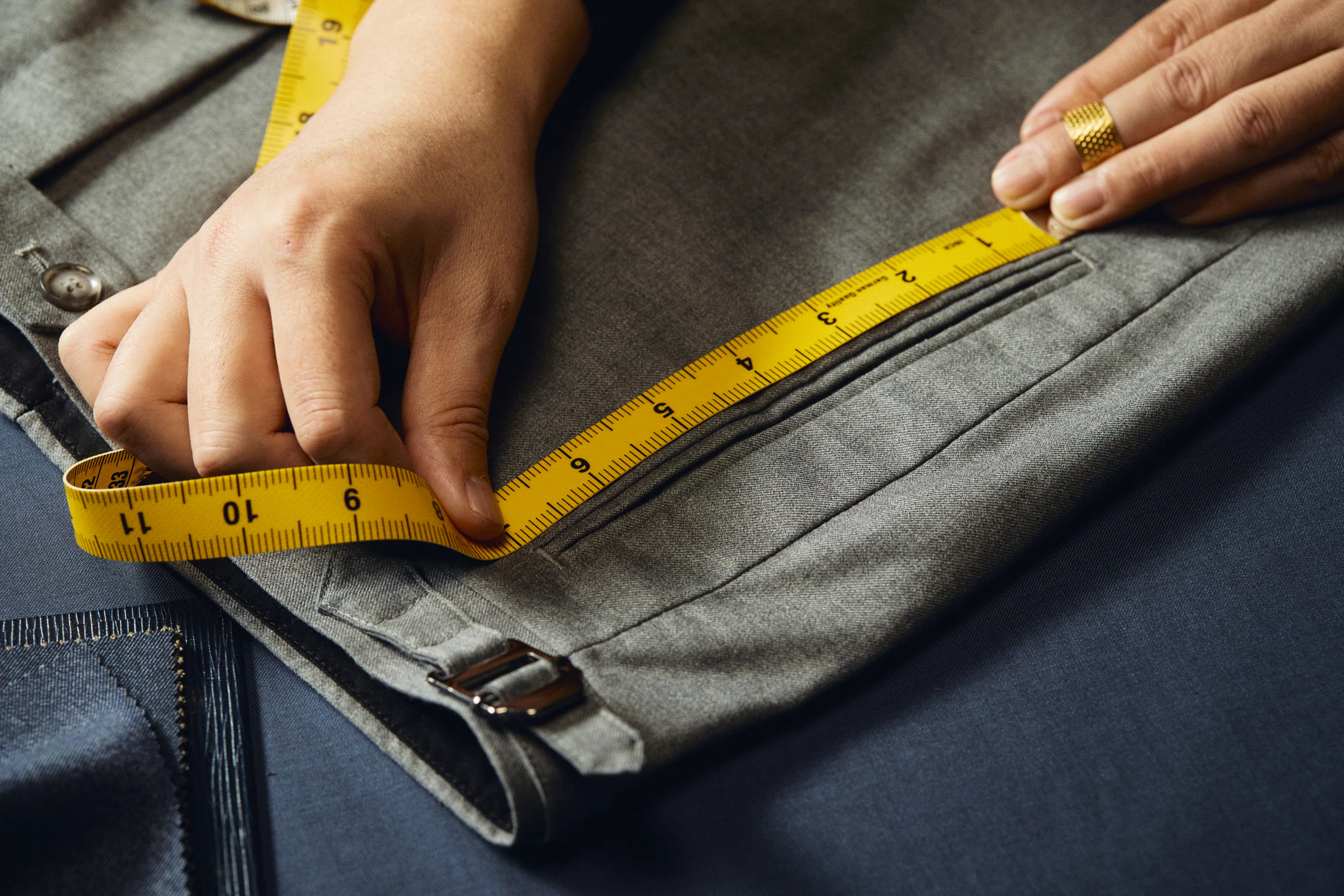 An individual trouser pattern being drafted on a tailoring table