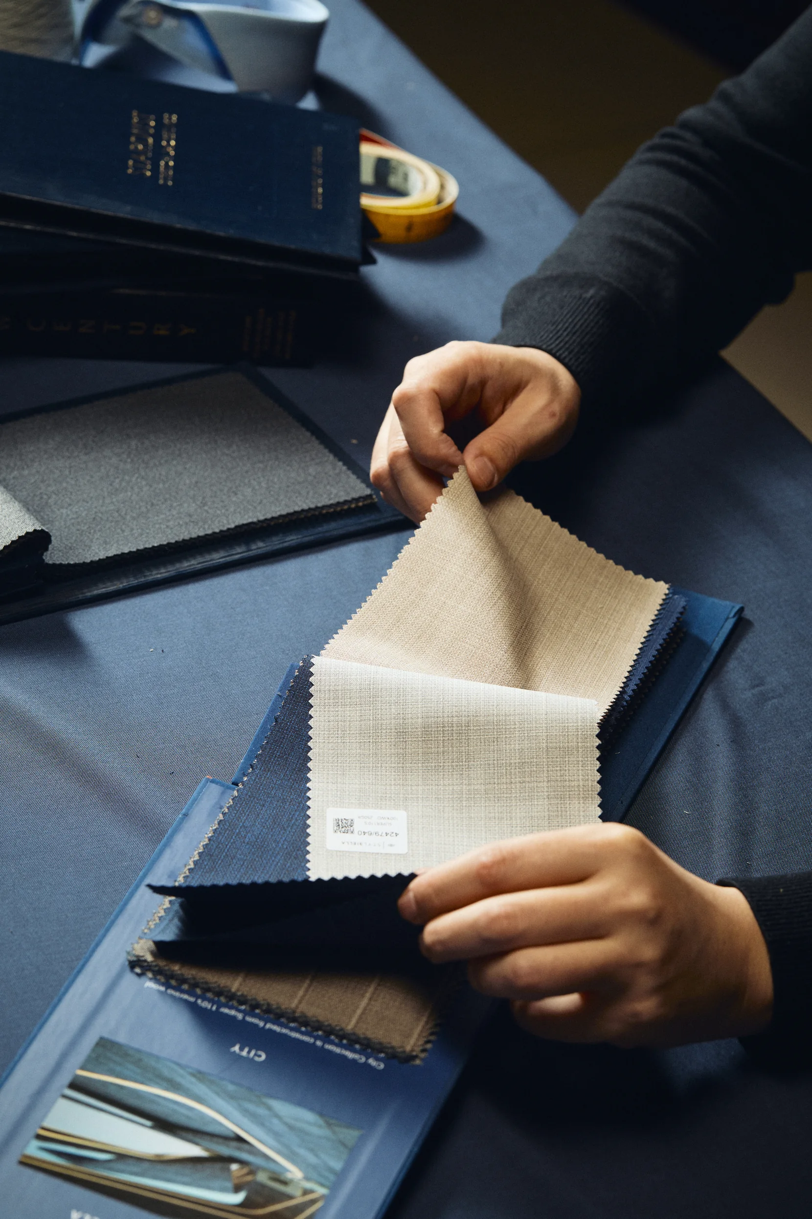 Premium jacket fabrics arranged on a tailor's worktable