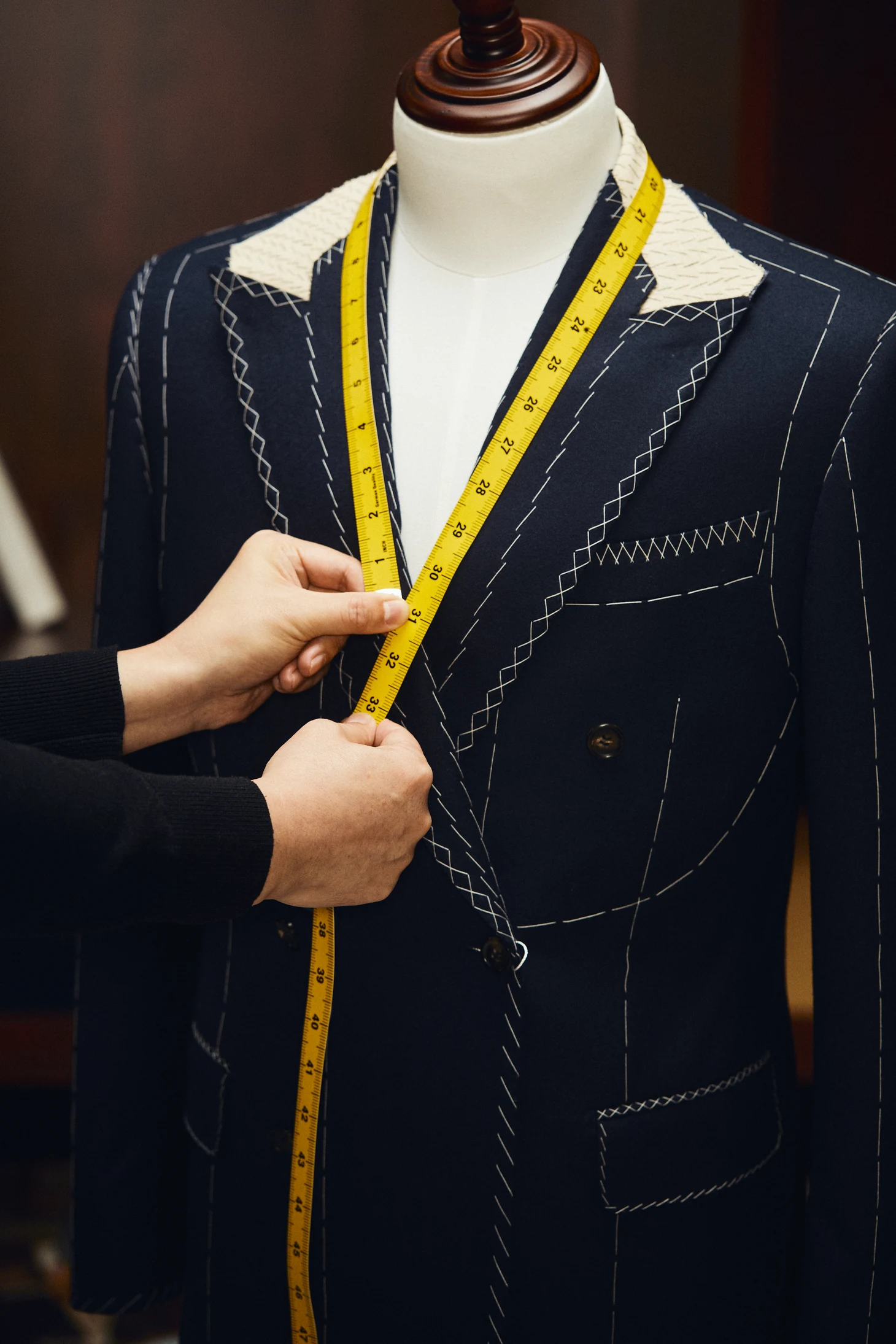 Tailor fitting a custom navy blazer