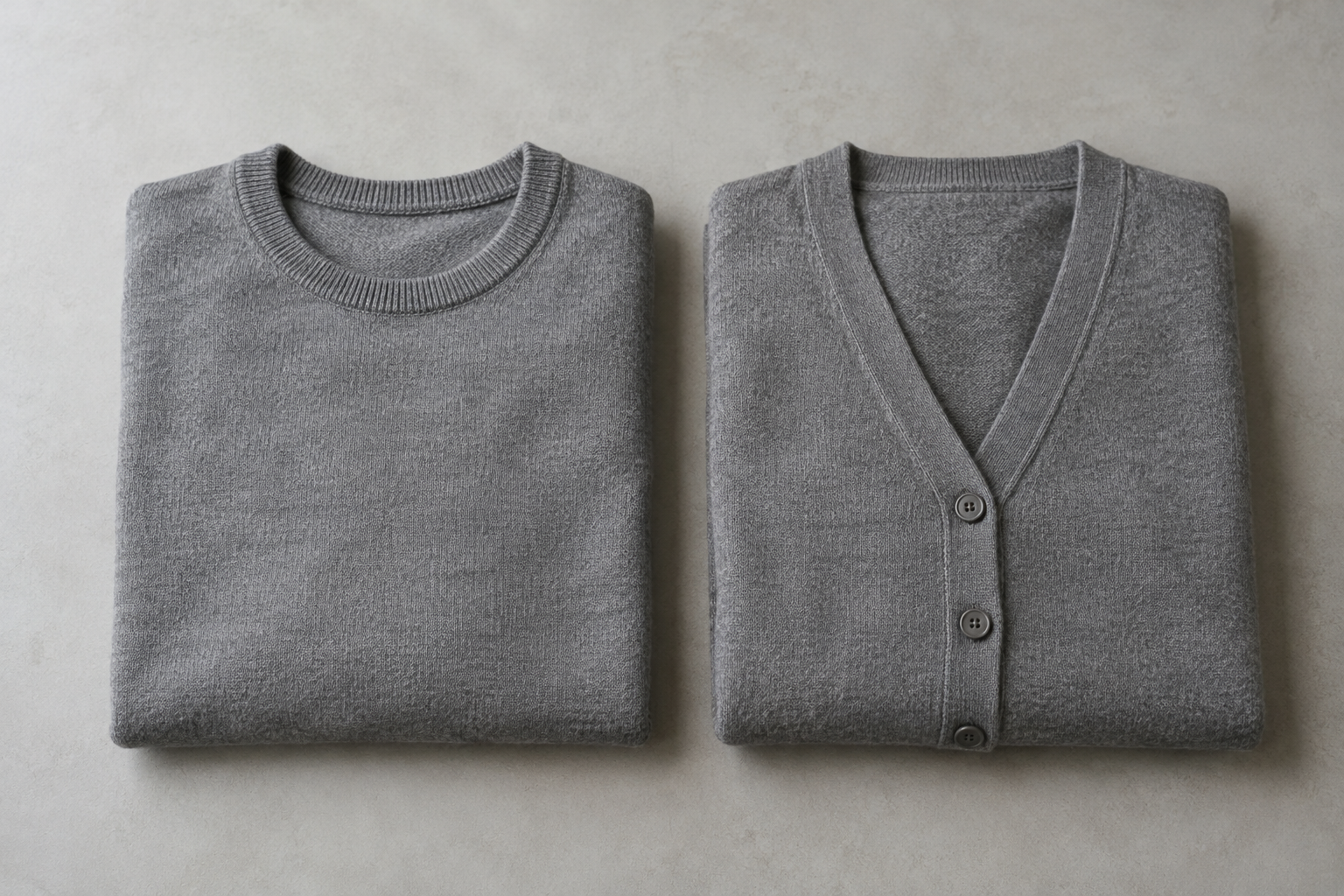 Folded grey crew-neck sweater beside a grey button-front cardigan